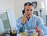 Foto: Ein telefonierender Mann an seinem Schreibtisch