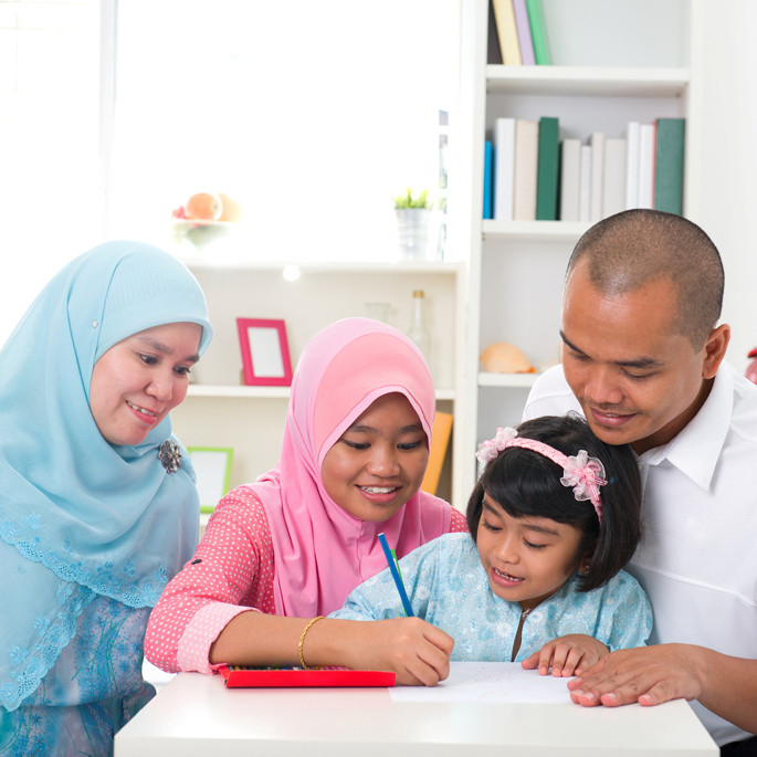 Indonesisches Elternpaar lernt mit ihren Kindern