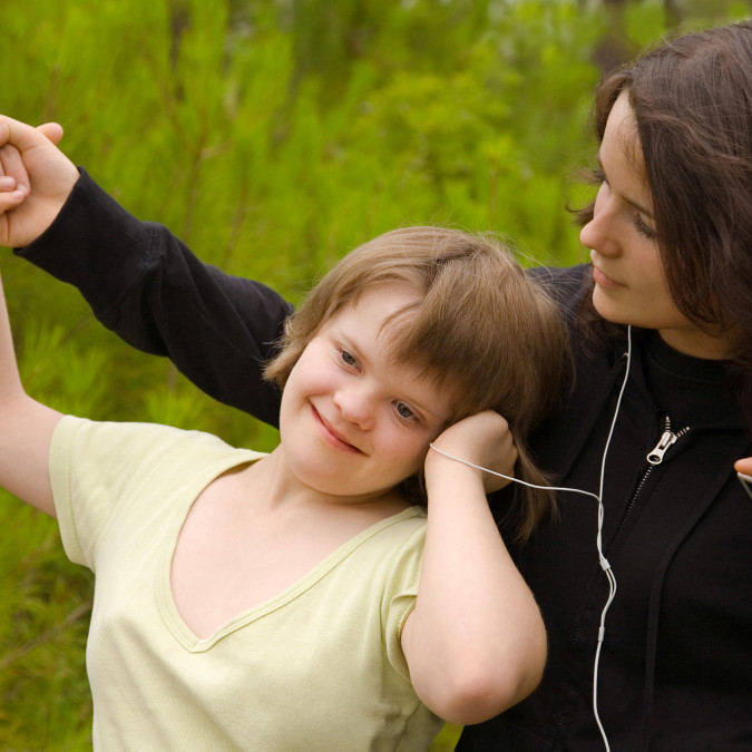 Ein Mädchen mit Down-Syndrom hört Musik über In-Ear-Kopfhörer