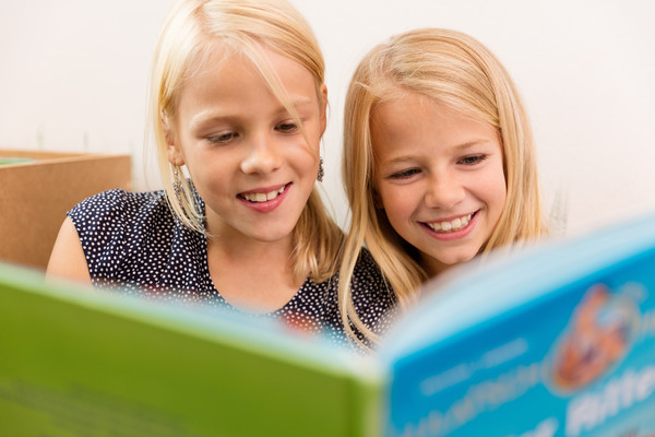 zwei Mädchen lesen ein Buch