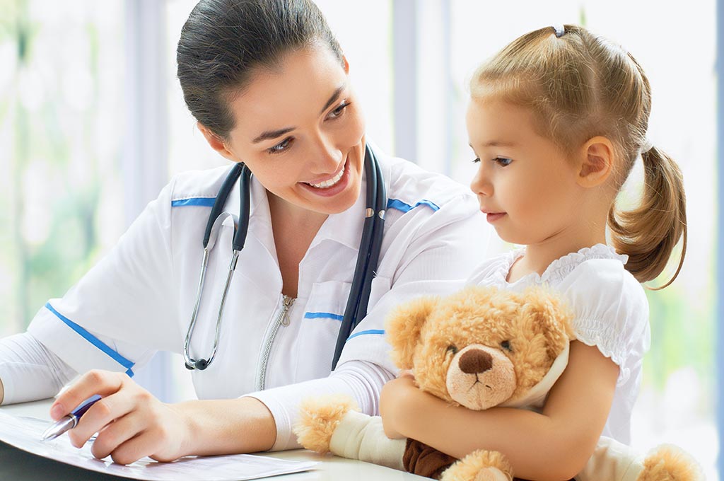 eine junge Ärztin spricht mit einem kleinen Mädchen