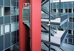 Das innen liegende Treppenhaus des Technischen Rathauses mit dem roten Aufzug