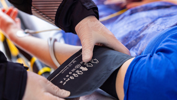 Einem Patienten wird ein Blutdruckmessgerät angelegt