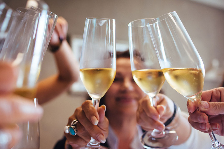 Nahaufnahme einer Gruppe von Freunden, die mit Champagnergl&auml;sern in der Hand ansto&szlig;en
