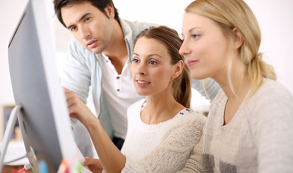 AdobeStock 57959214 Eine Frau erklärt einer anderen Frau etwas an einem Computermonitor