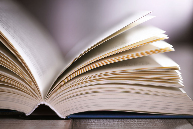 Komposition mit einem aufgeschlagenen Buch auf dem Tisch 