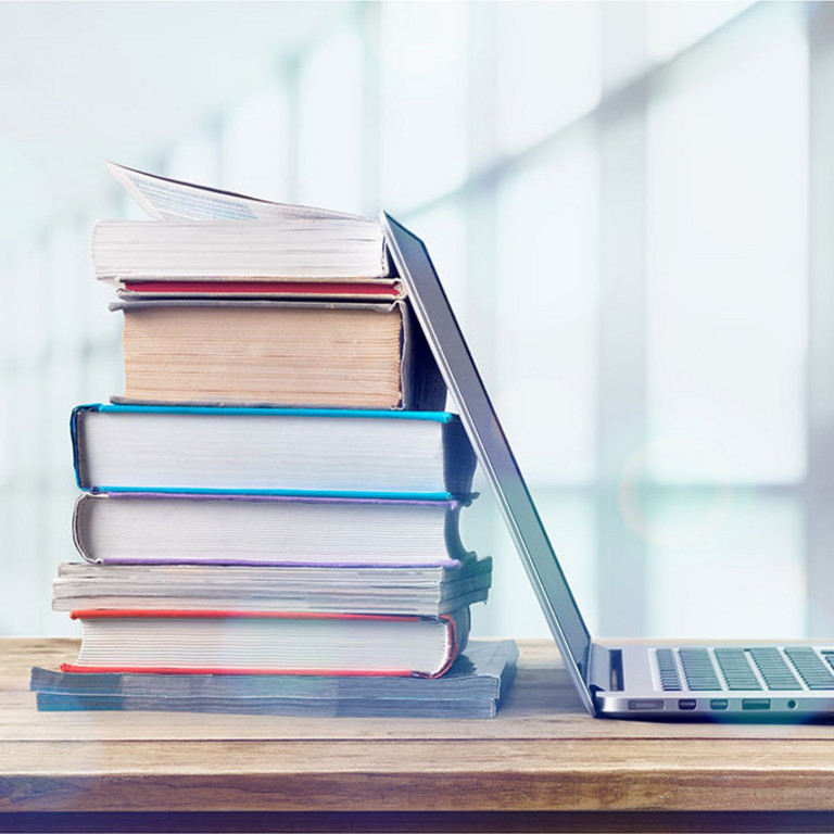 Ein Stapel Bücher mit einem Laptop Ein Stapel Bücher mit einem Laptop
