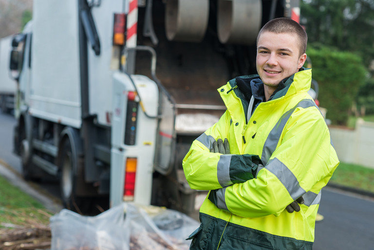 Ein Mann steht vor einem M&uuml;llfahrzeug