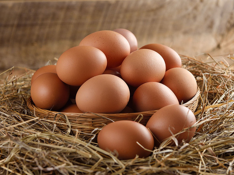  Eier in einem Korb auf Stroh