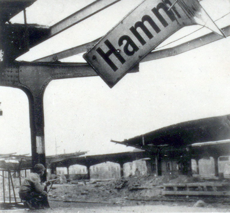 US-Soldat hockt auf dem Bahnhof in Hamm, 6. April 1945