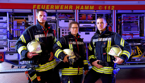 Feuerwehrleute der Stadt Hamm stehen vor einem Feuerwehrauto