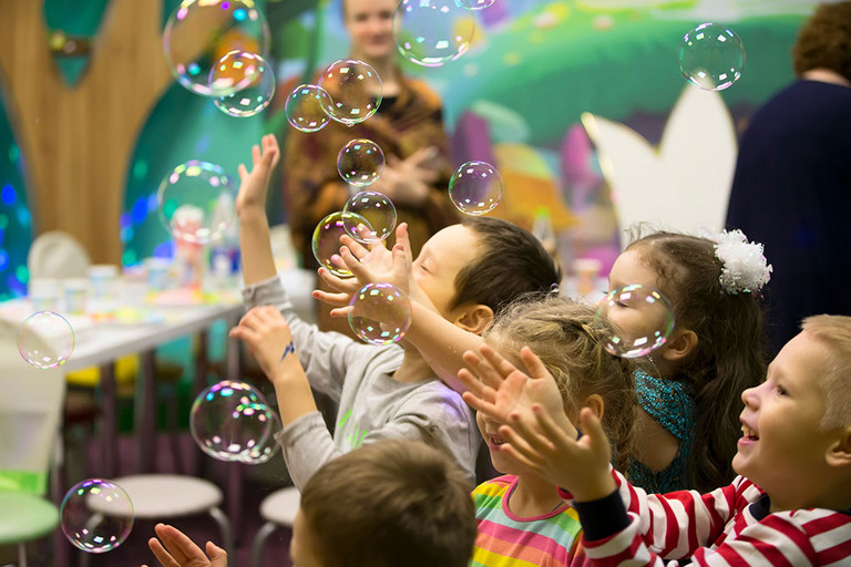 Seifenblasenshow. Kinderfest. Kinder, die Seifenblase zerplatzen lassen.