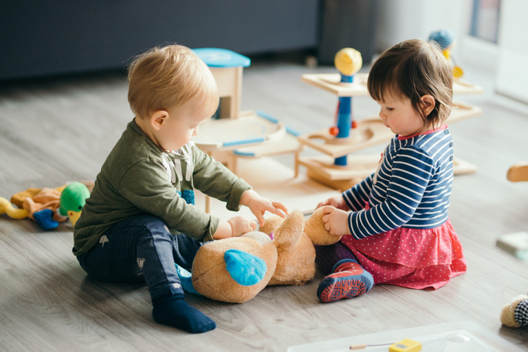 Ein kleiner Junge und ein kleines Mädchen spielen mit Spielzeug Ein kleiner Junge und ein kleines Mädchen spielen mit Spielzeug