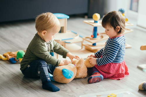 Ein kleiner Junge und ein kleines Mädchen spielen mit Spielzeug