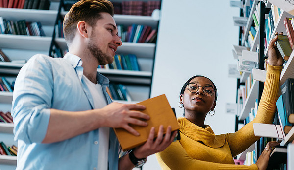 AdobeStock 362856249 Ein Mann und eine Frauen stehen vor einem Bücherregal