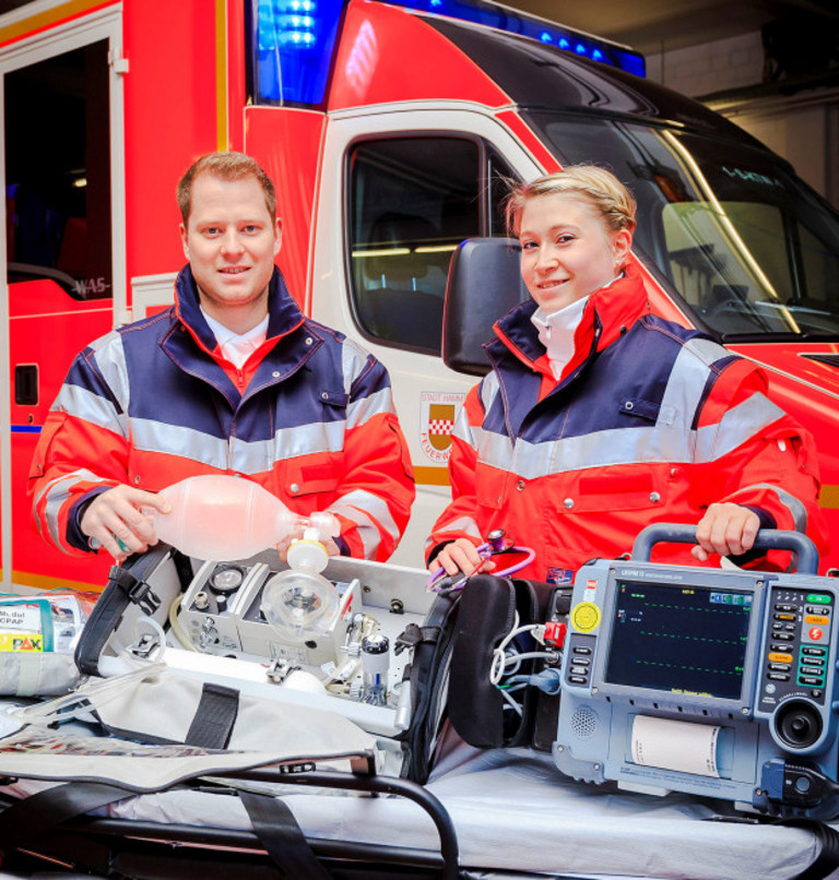 Zwei Rettungssanitäter der Feuerwehr Hamm vor einem RTW