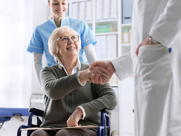 AdobeStock 252046248 Arzt schüttelt einer Seniorin die Hand