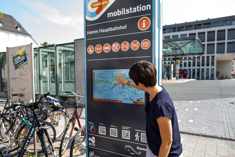 Frau steht vor Schild Mobilstation am Hauptbahnhof