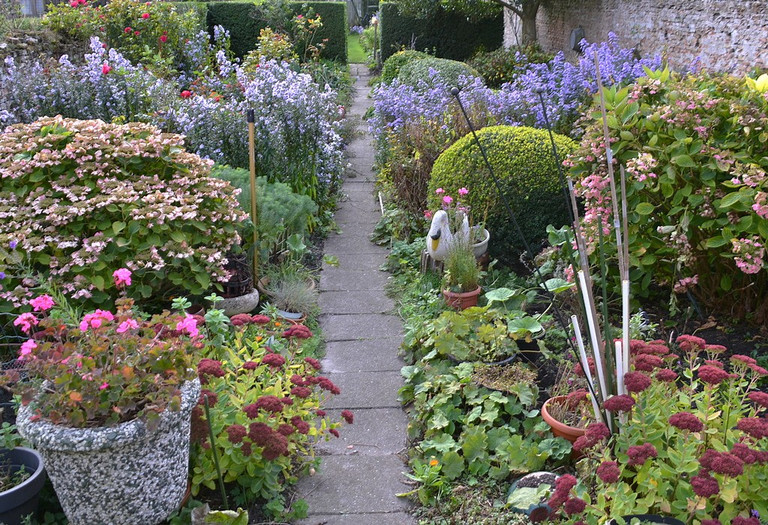Das Foto zeigt einen Blumengarten mit befestigten Weg