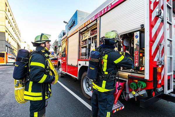 Zwei Feuerwehrleute an einem Feuerwehrauto
