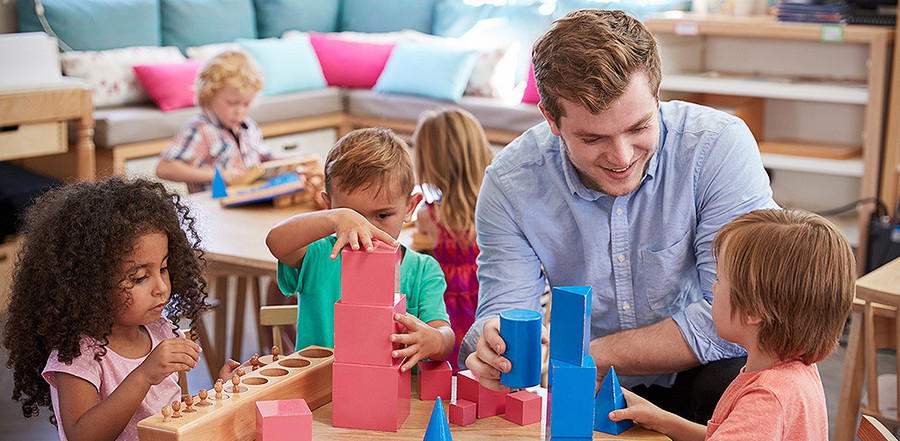 Die Themen Ein Erzieher spielt mit Kindern in der Kita