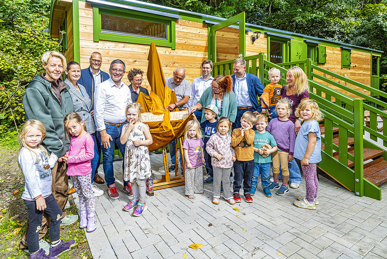 Eine Gruppe von Kindern und Erwachsenen mit dem OB  vor dem neuen Bauwagen der Kita Sylverberg.