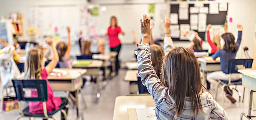 Die Themen aufzeigende Kinder in einer Unterrichtsklasse