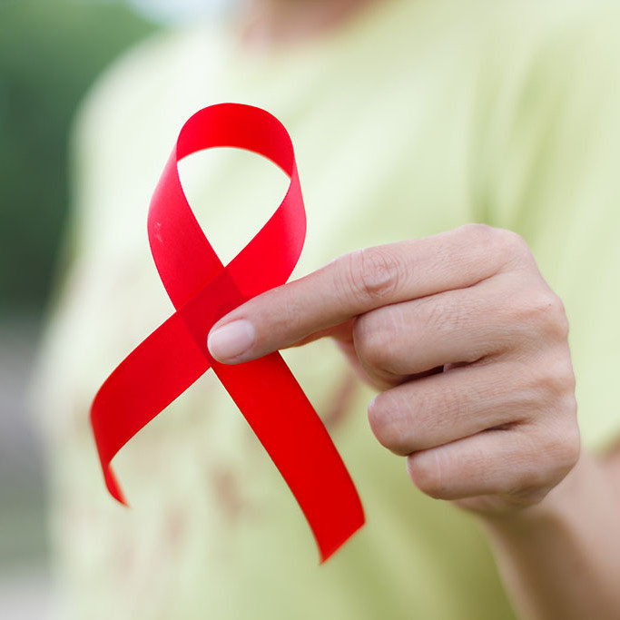 Eine Frau hält eine Aids-Schleife