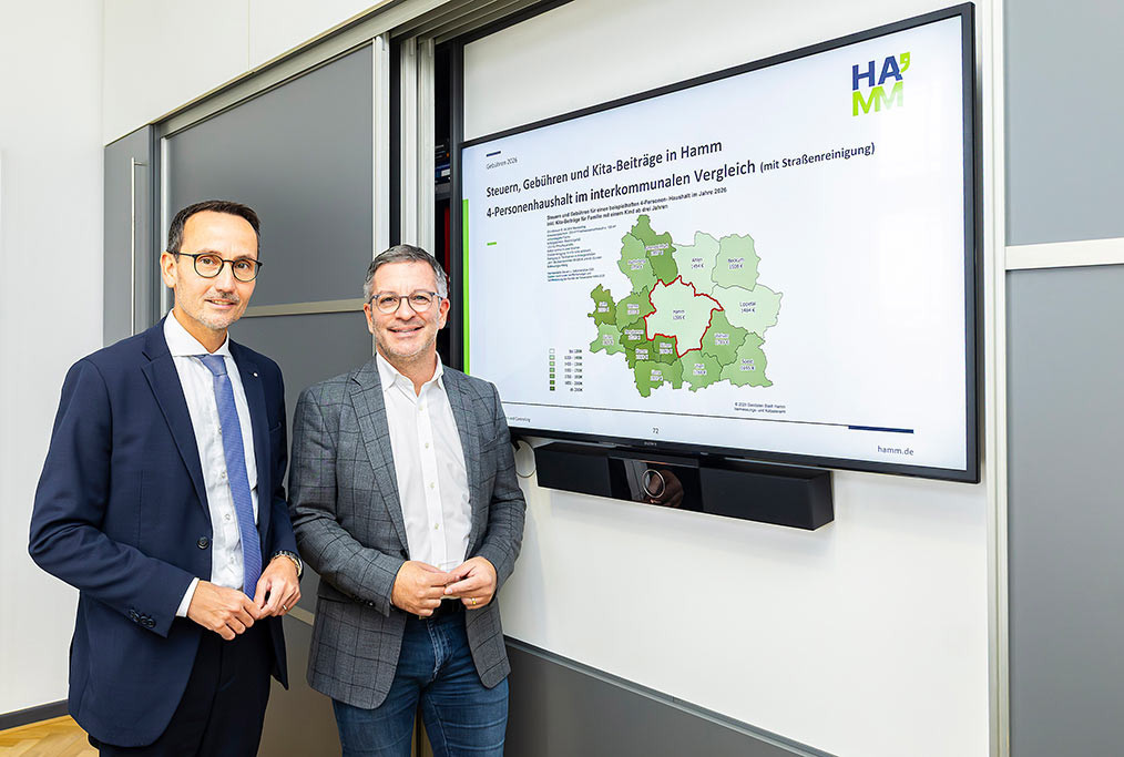 Stadtkämmerer Markus Kreuz und Oberbürgermeister Marc Herter stehen vor eine Präsentation zur Kommunalen Gebührenplanung