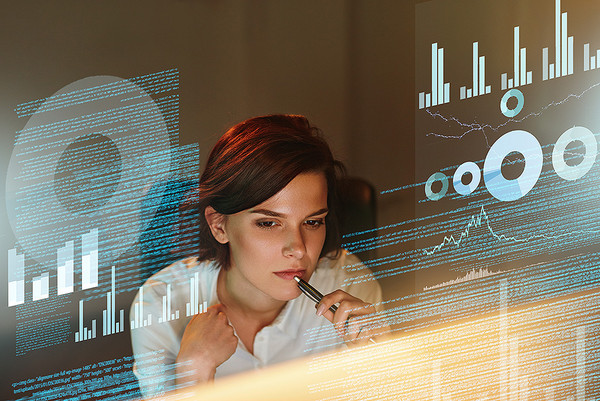 Eine Frau sitzt vor einem Computerbildschirm und programmiert 