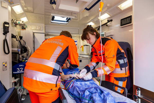 Zwei Notfallsanitäter versorgen eine Patientin