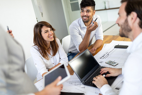 AdobeStock 404530571 Mehrere Menschen sitzen an einem Tisch und unterhalten sich über vorliegende Unterlagen