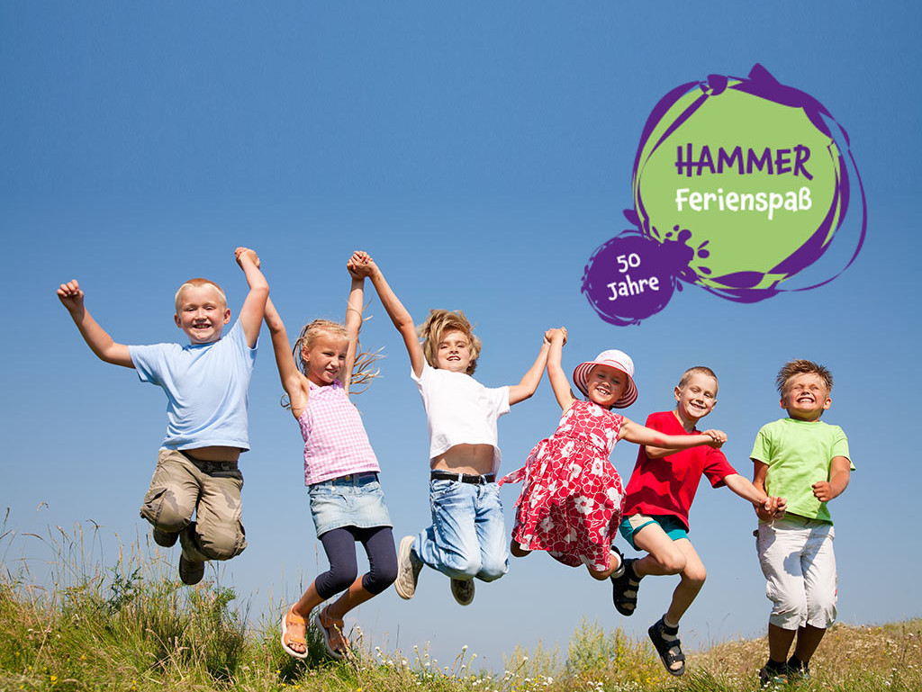 Eine Gruppe fröhlicher Kinder hält sich an den Händen fest und springt in die Höhe 