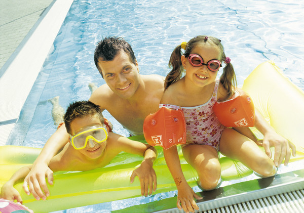 Vater mit zwei Kindern im Schwimmbad
