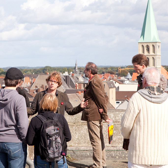 Touristen beim Stadtrundgang auf dem Dach des OLG