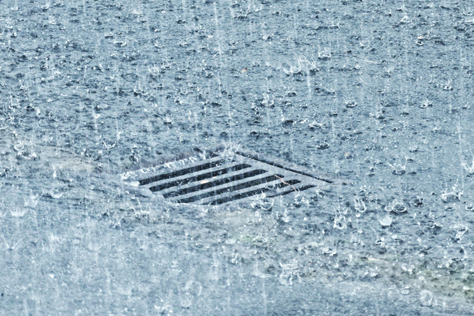 Starker Regen prasselt auf eine Stra&szlig;e nieder