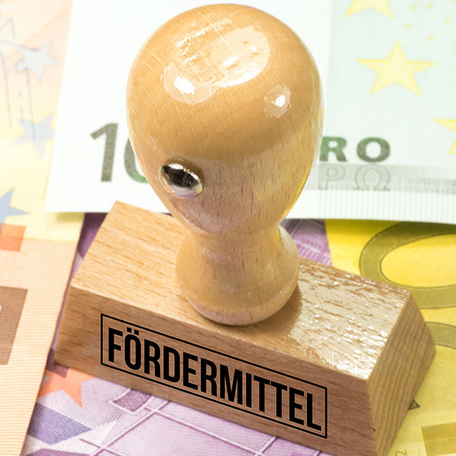 Euro Geldscheine und ein Stempel mit dem Aufdruck F&ouml;rdermittel