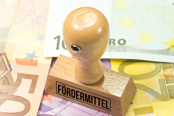 Euro Geldscheine und ein Stempel mit dem Aufdruck Fördermittel