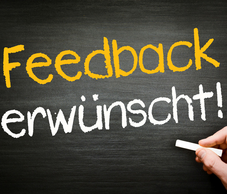 Mit Kreide auf einer Tafel geschrieben: "Feedback erw&uuml;nscht!"