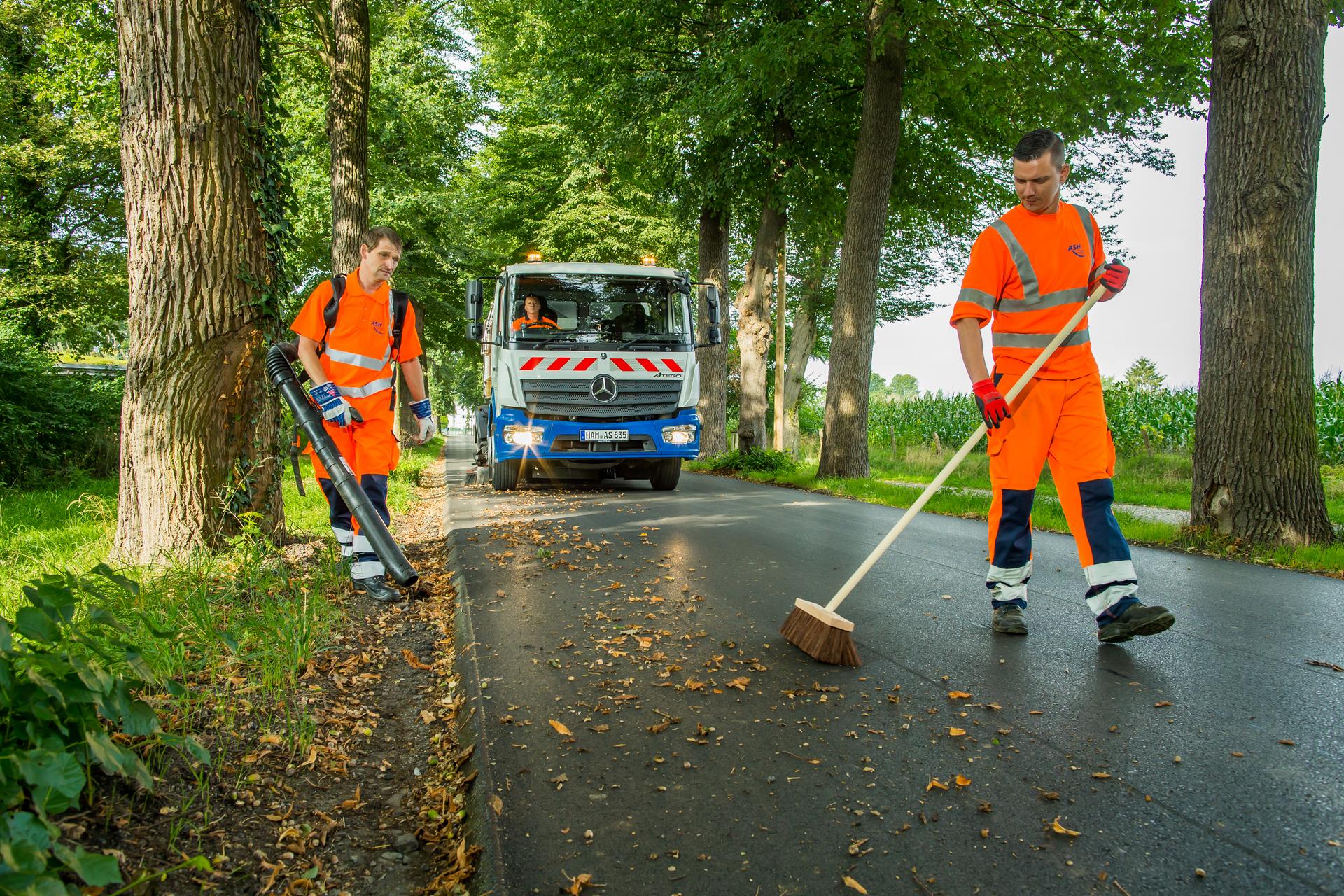 Mitarbeiter der Stadtreinigung säubern eine Straße