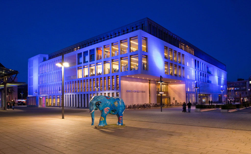 blau illuminiertes Heinrich-von-Kleist-Forum am Abend mit Elefant im Vordergrund