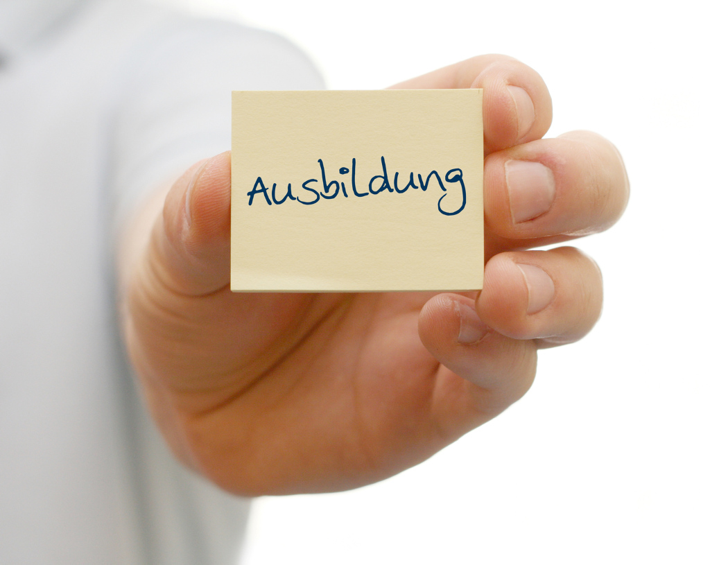 Ein Hand hält einen Zettel mit der Aufschrift "Ausbildung"