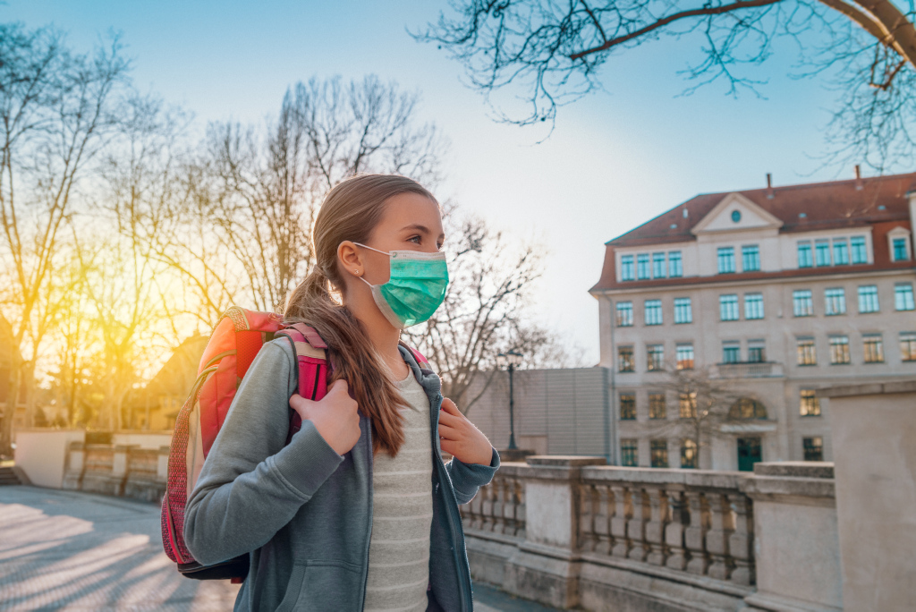 AdobeStock 336596092 Mädchen mit Mundschutz auf dem Weg zur Schule