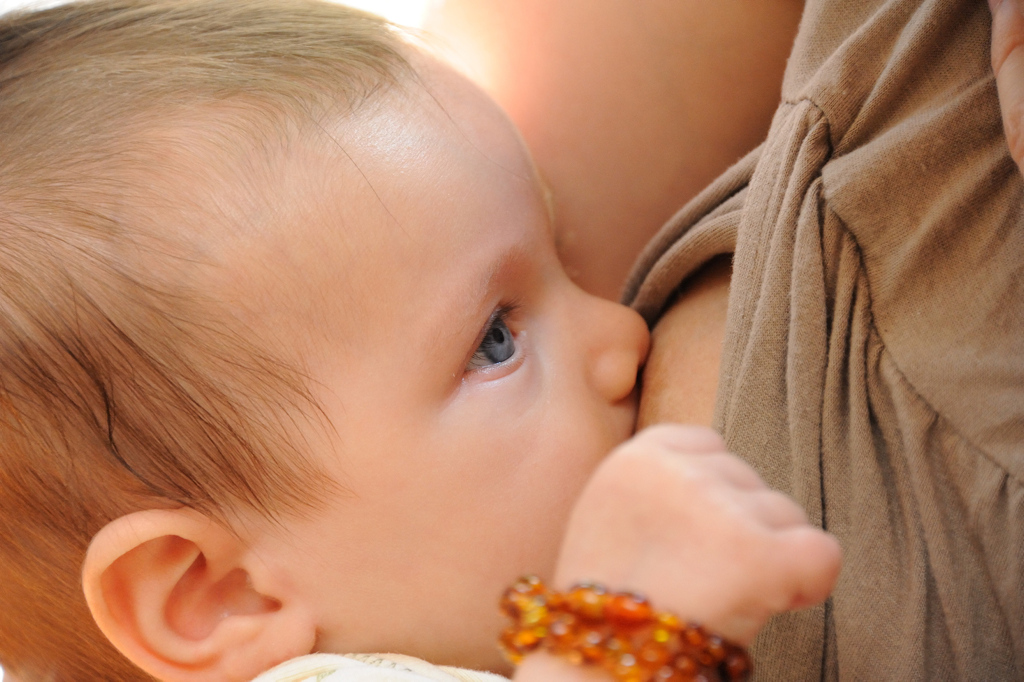ein Baby trinkt an der Brust seiner Mutter