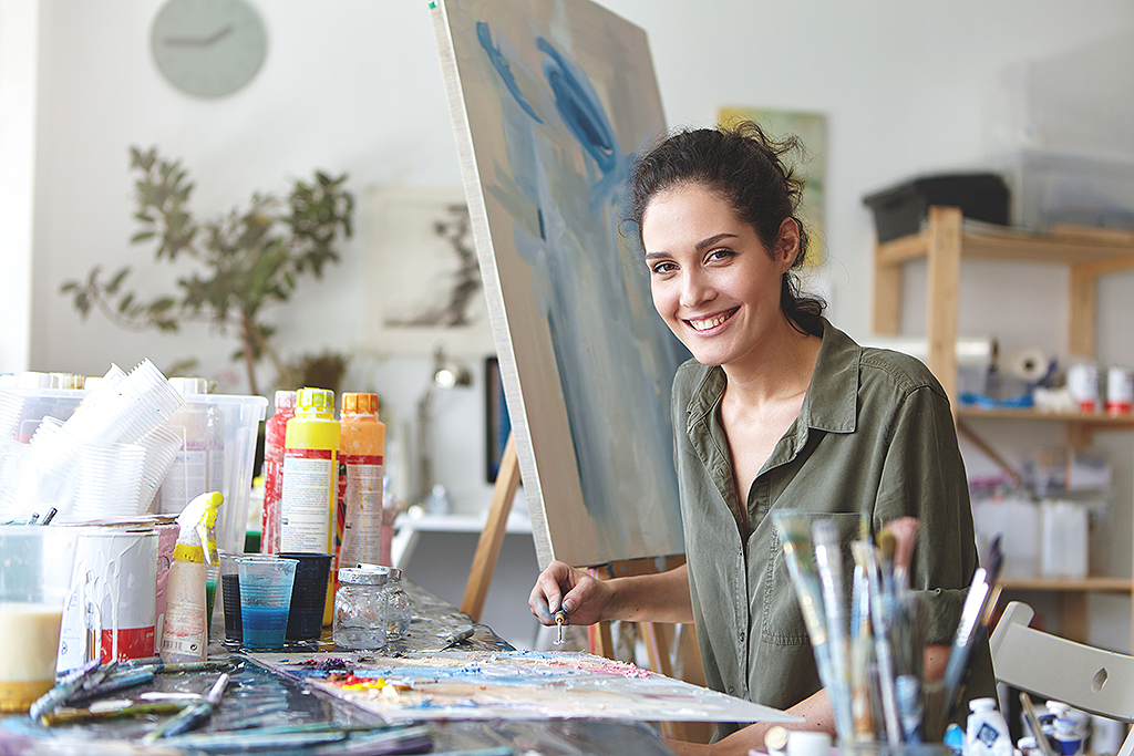 Ein Frau malt in ihrem Atelier