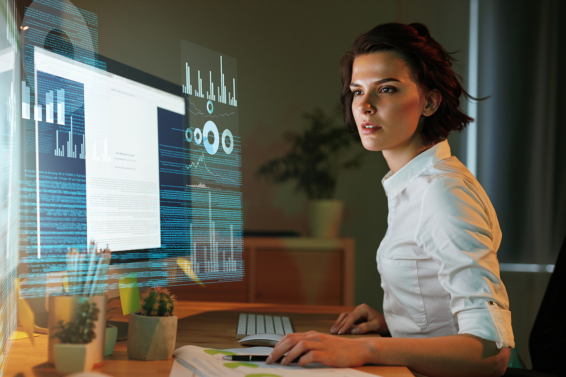 Eine Frau sitzt vor einem Computerbildschirm und programmiert Eine Frau sitzt vor einem Computerbildschirm und programmiert