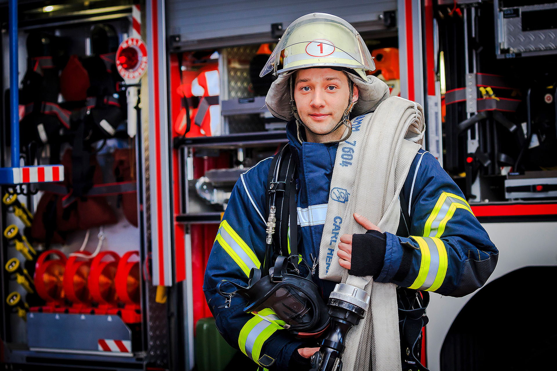 Ein Feuerwehrmann vor einem Feuerwehrauto Ein Feuerwehrmann vor einem Feuerwehrauto