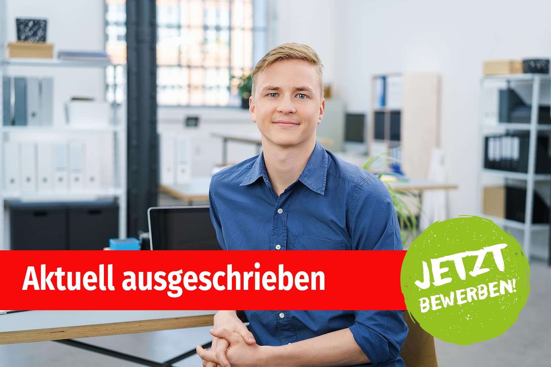 Ein junger Mann sitzt vor seinem Schreibtisch im Büro Ein junger Mann sitzt vor seinem Schreibtisch im Büro