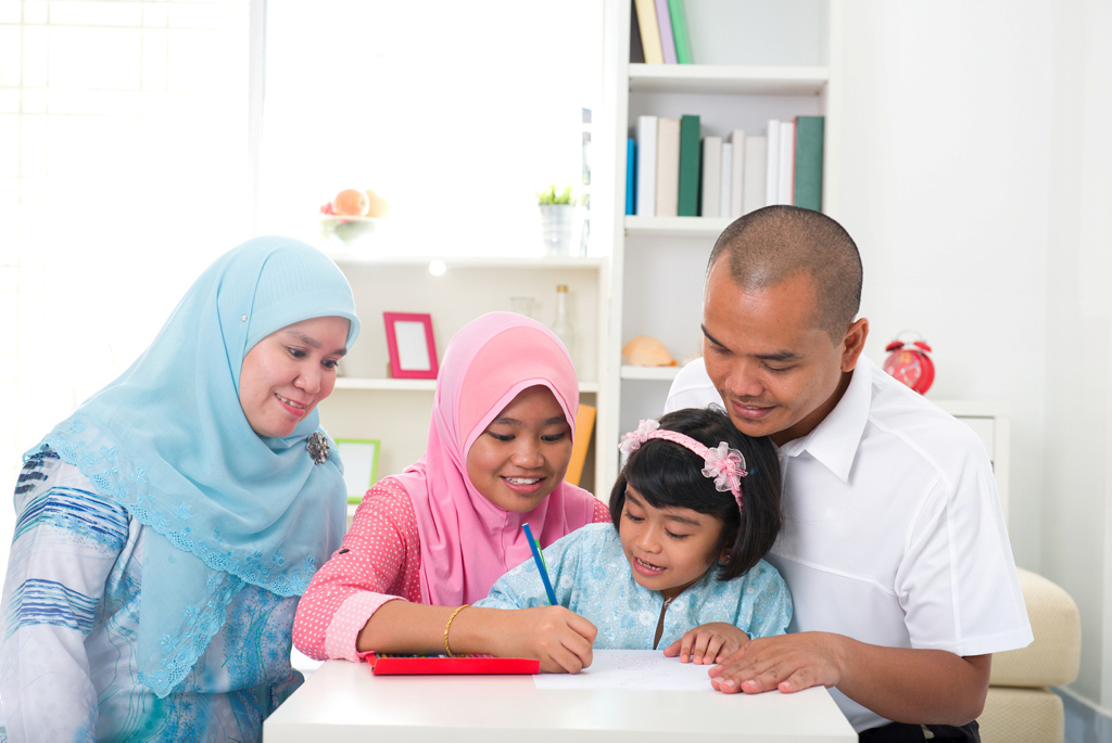Indonesisches Elternpaar lernt mit ihren Kindern
