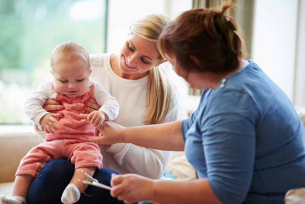 Eine Beraterin spricht mit einer Mutter mit Baby